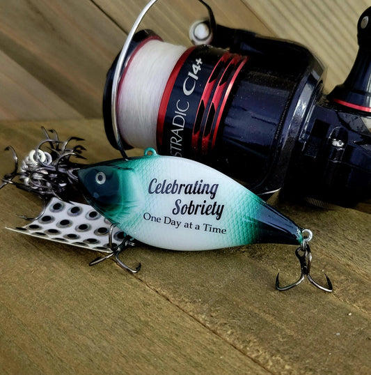 Personalized sobriety fishing lure with “1 Year Sober” text — recovery milestone gift hand-painted on Cape Cod.